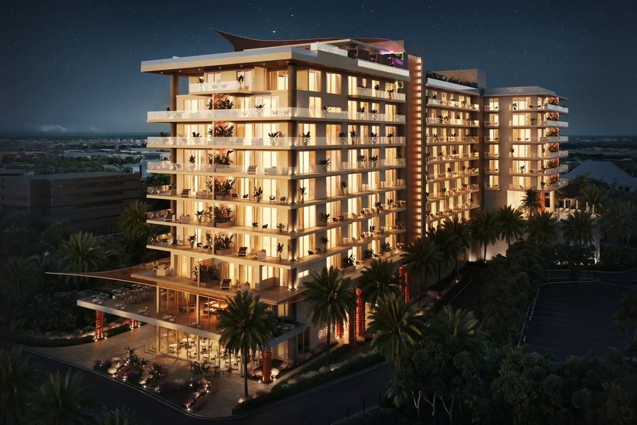 One GT Hotel 3D Visualization showing the illuminated hotel exterior with landscaped grounds and palm trees