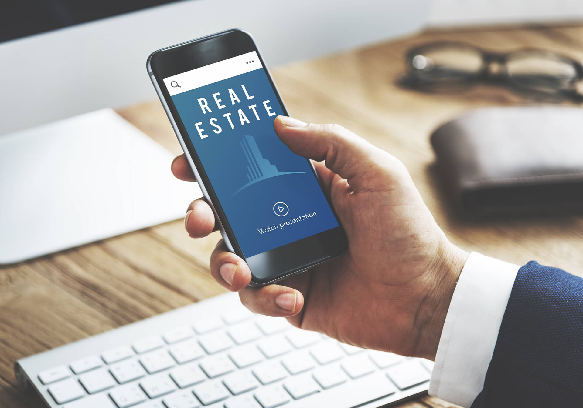A Realtor Using Mobile Device To View A Presentation