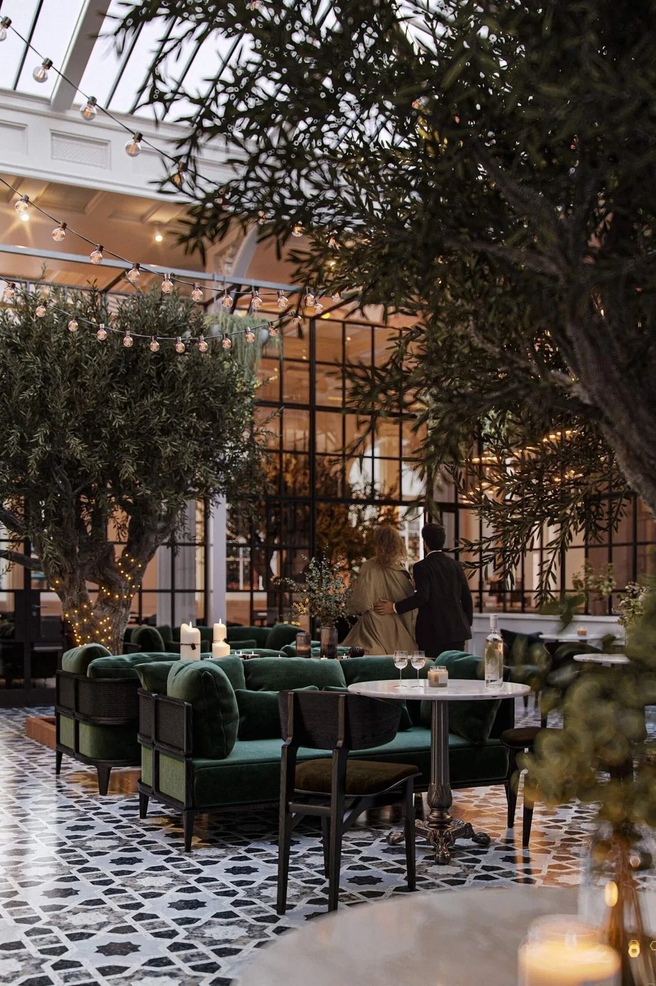 3D visualization of a restaurant interior with green velvet chairs and olive trees