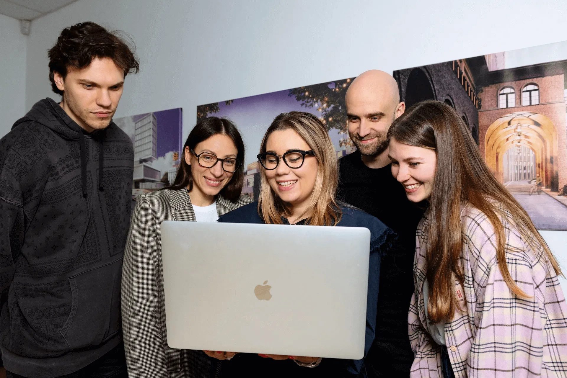 ArchiCGI project managers looking at a laptop together while working on an agency project
