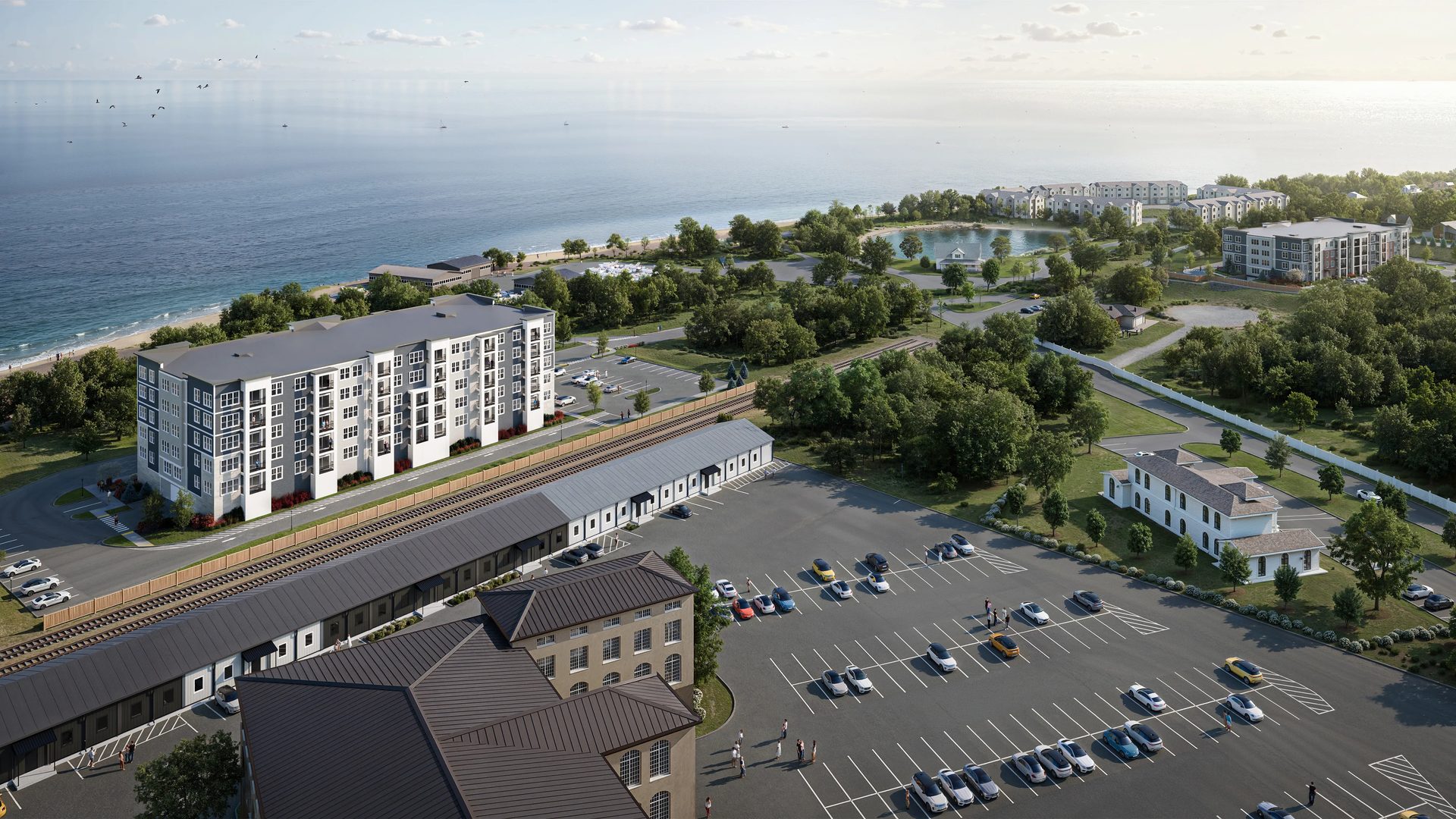 Aerial CGI of a waterfront multifamily development with apartment buildings, commercial spaces, and ocean views