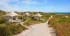 3D visualization of tent-roofed glamping cabins on sand dunes along the Australian coastline with ocean views