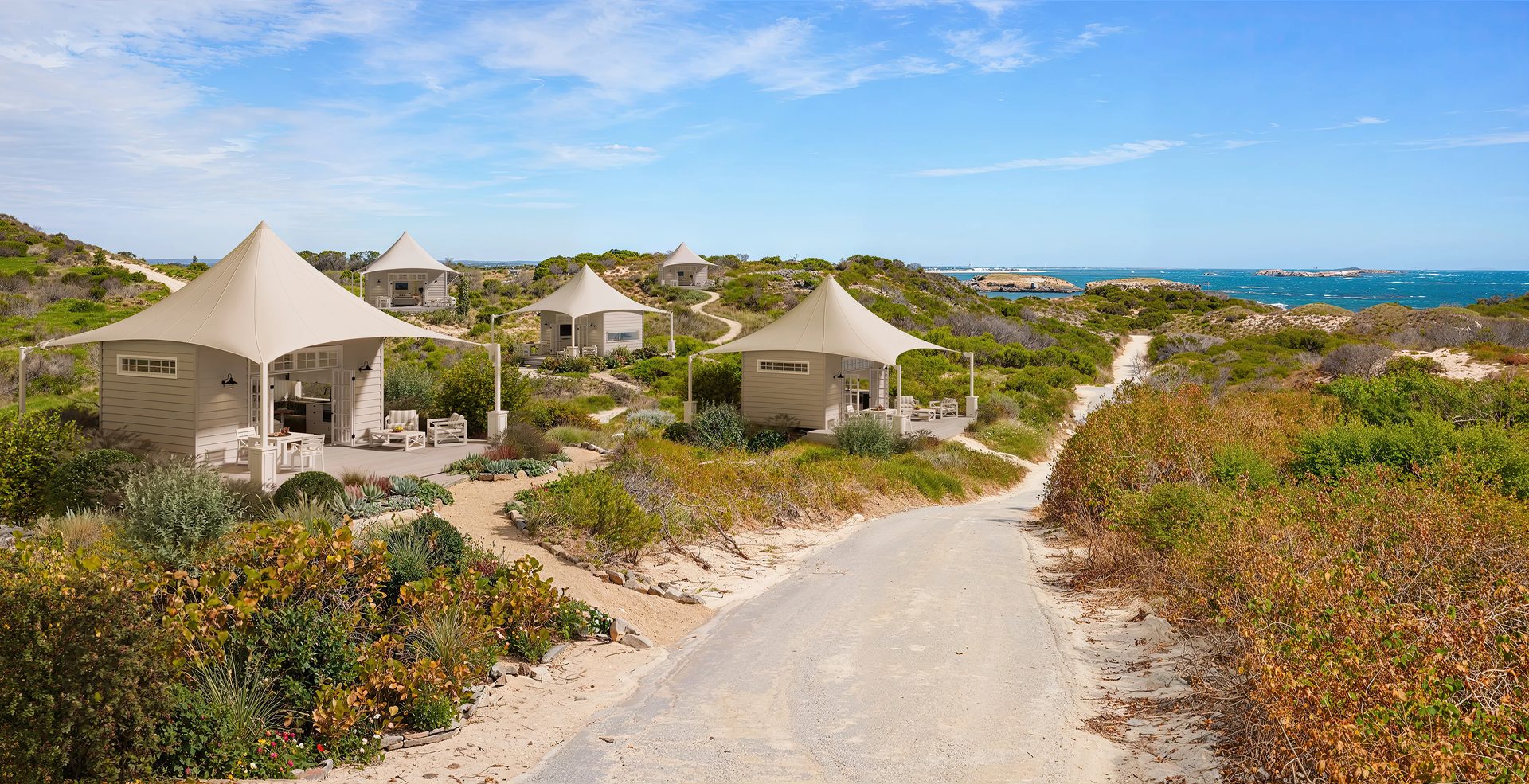 3D visualization of tent-roofed glamping cabins on sand dunes along the Australian coastline with ocean views