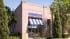 Architectural CGI of a pink stucco ice cream parlor with a striped awning and branded signage in California
