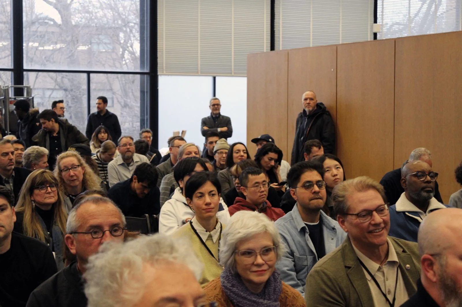 Audience at a session of the ACSA Annual Meeting in a glass-walled modernist hall