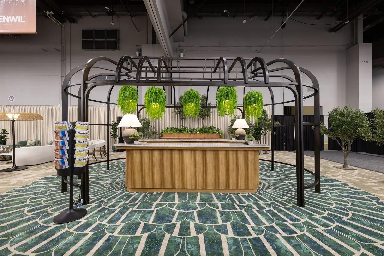HD DesignWell Pavilion with a black metal pergola and hanging plants on the HD Expo show floor at Mandalay Bay