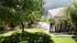 Exterior 3D visualization of a shaded hillside lawn overlooking a villa terrace, blossoming cherry tree, palms and Lake Como