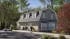 Architectural 3D visualization of a stone-clad fitness facility with gambrel roof, dormer windows, golf cart parking, and landscaped surroundings