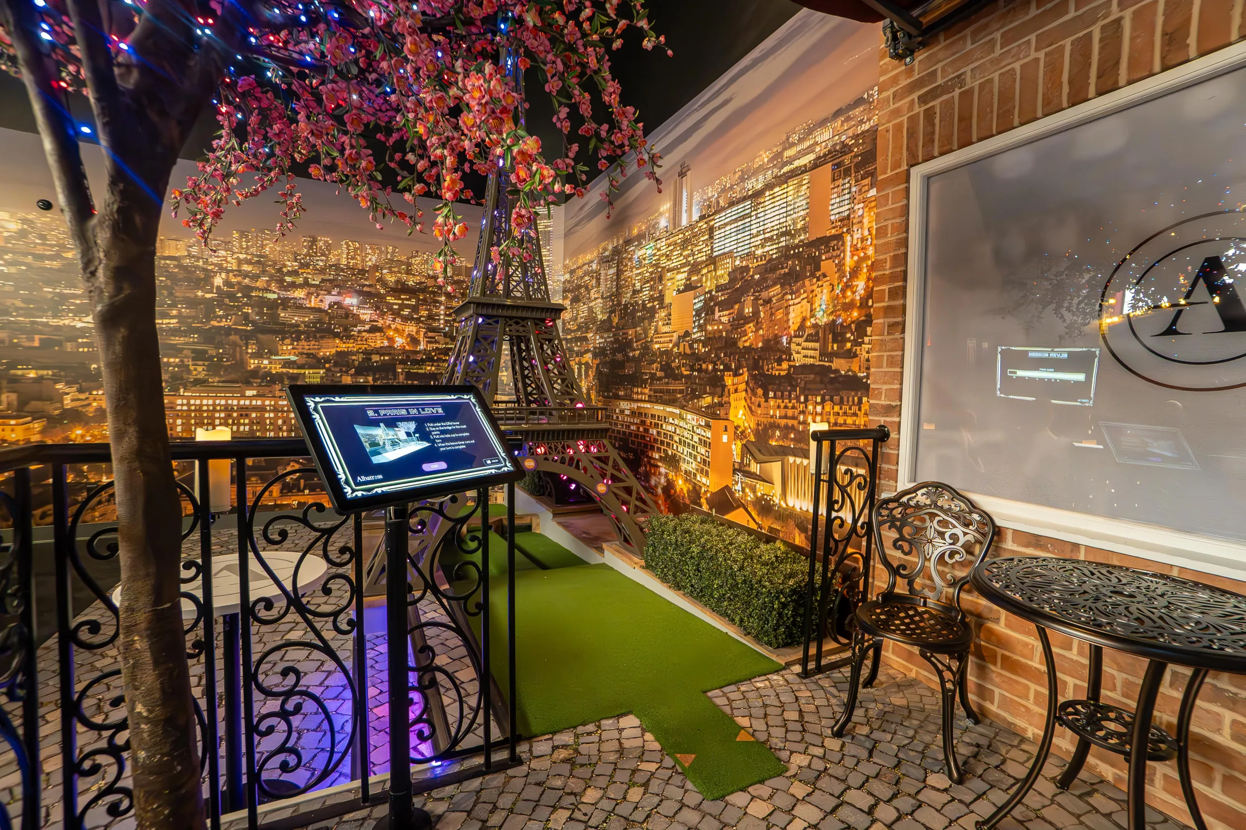 A photo of an entertainment center mini golf course styled with the Eiffel Tower and Paris scenery