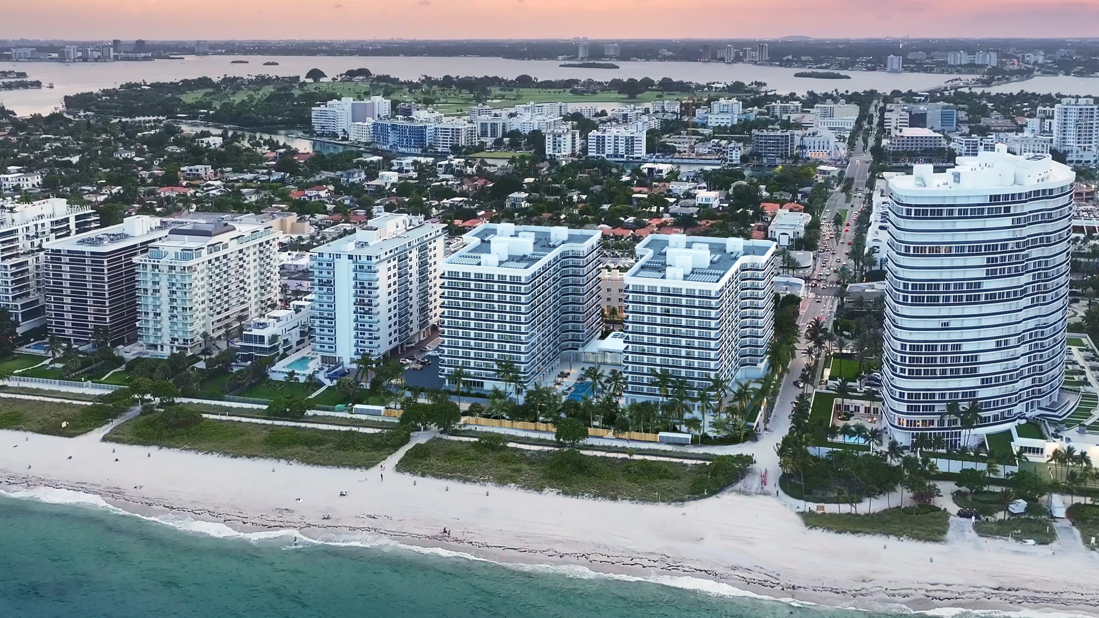 Aerial view of a coastal residential complex with beachfront buildings and shoreline captured in a detailed 3D rendering